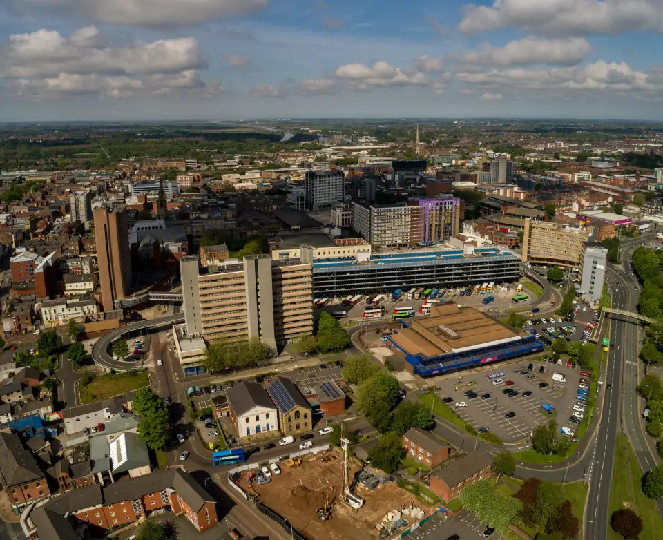 Aerial view of Preston city centre on a sunny day, with the bus station, office blocks and red-brick streets stretching towards the horizon
